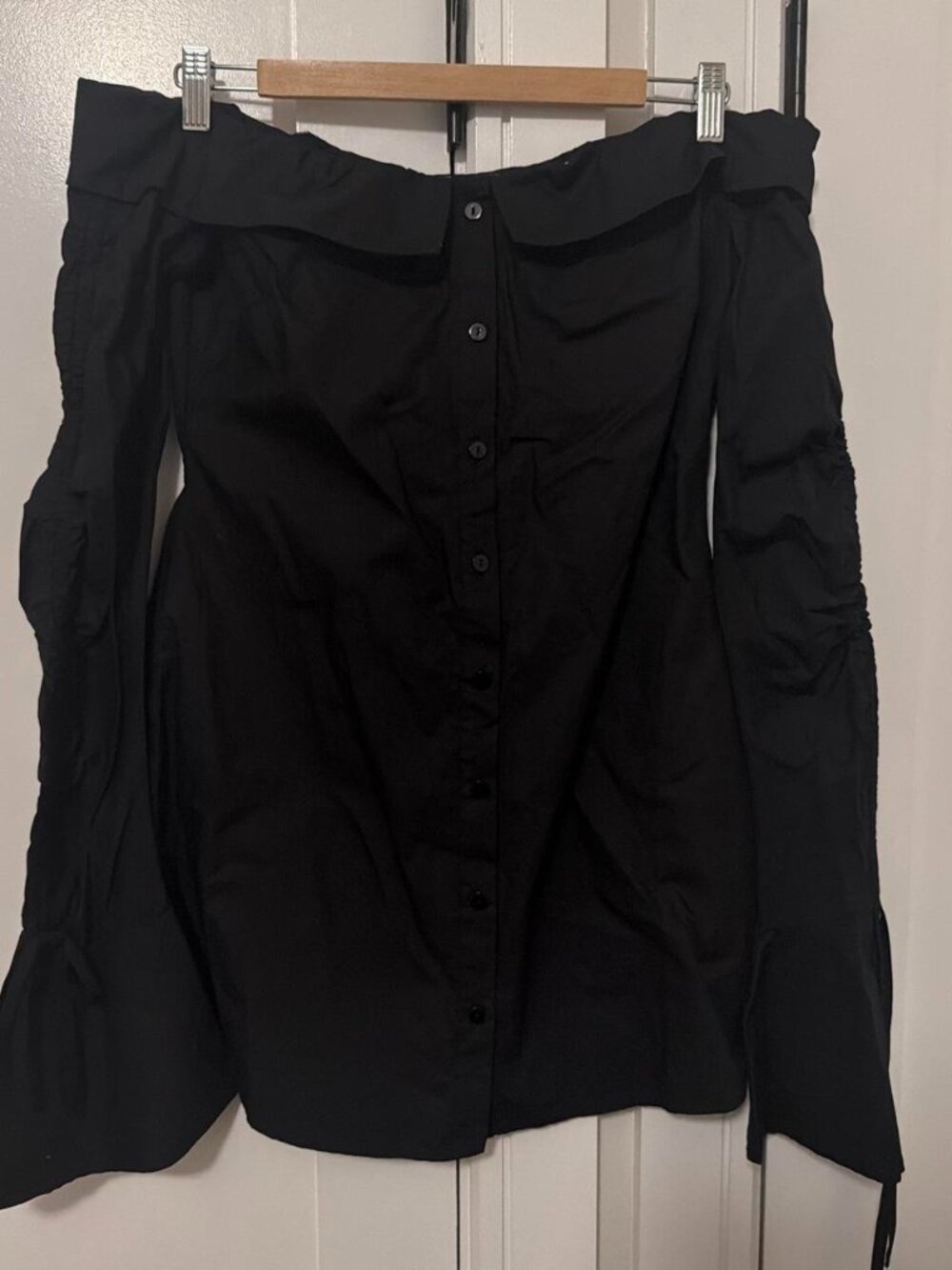 Black off the shoulder blouse with button-up front and ruffled sleeves